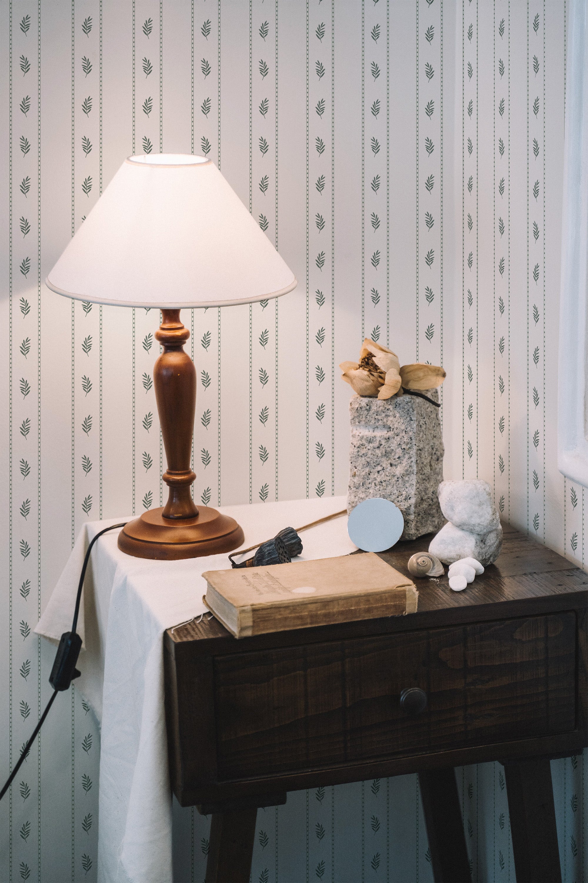 Self-adhesive wallpaper with a repeating pattern of olive branches on vertical lines, giving a vintage look to the room's decor.