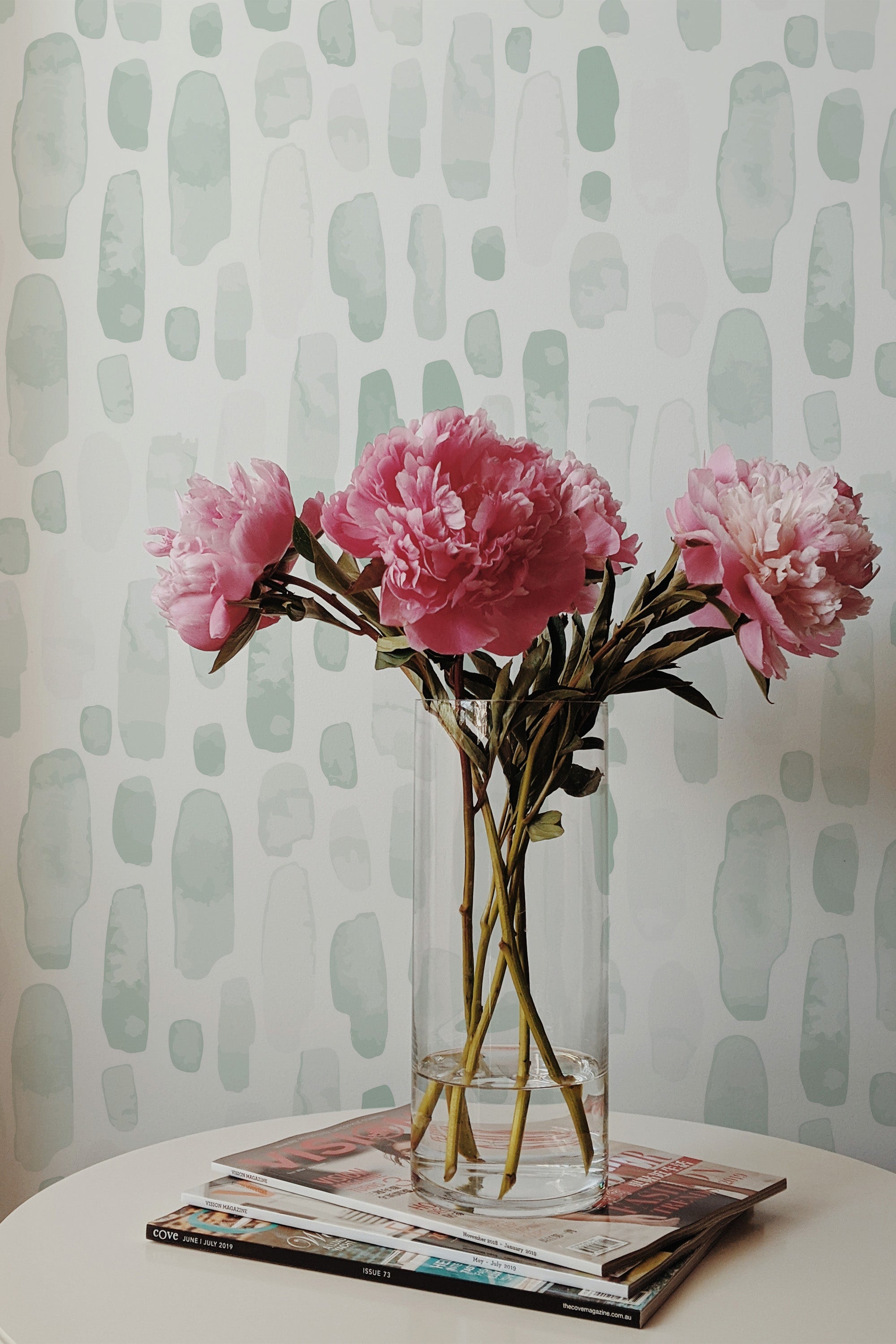 Self-adhesive wallpaper with a green watercolor drops pattern, creating a soft, organic feel.