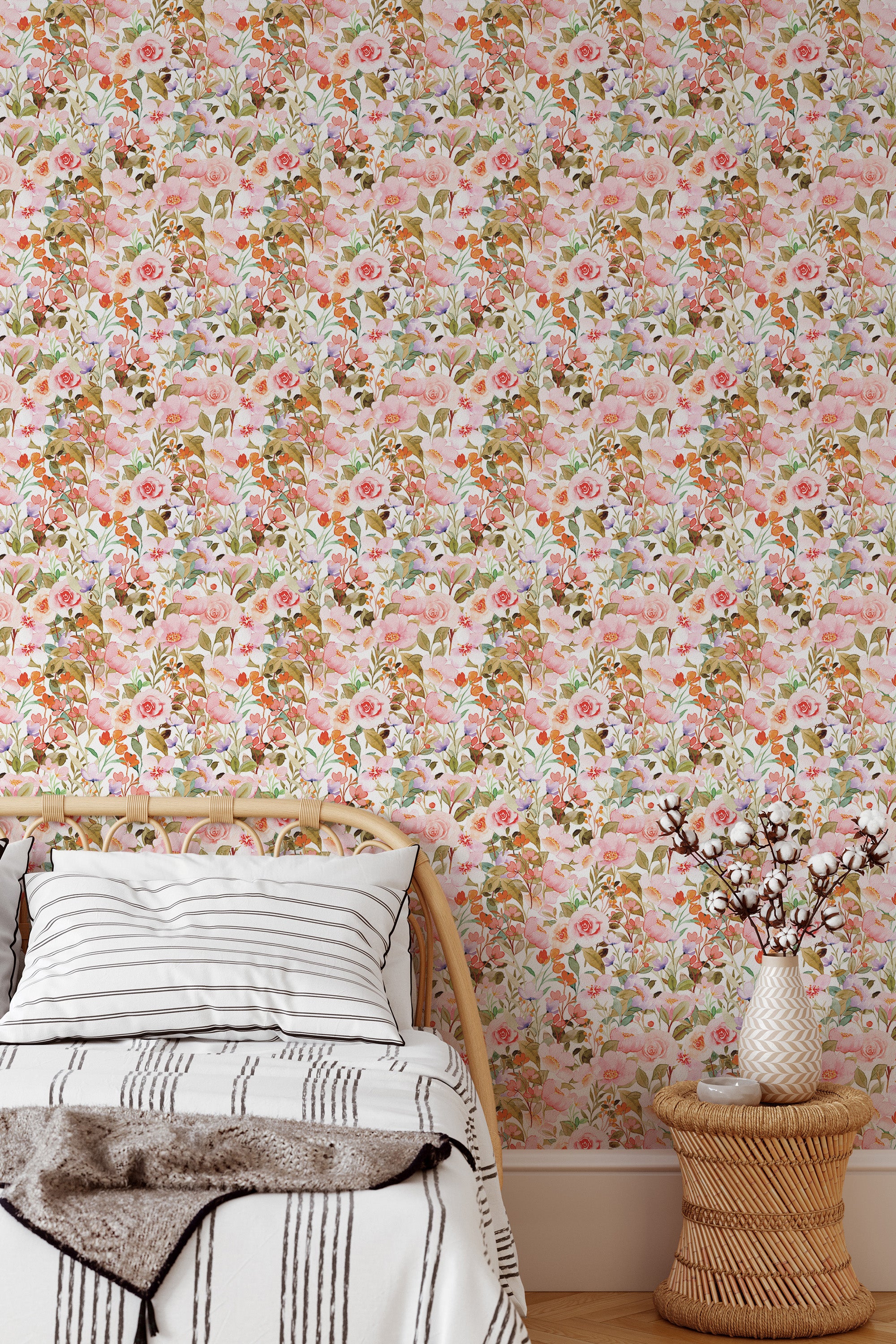 Self-adhesive pink spring floral wallpaper with a repeating pattern of pink and white flowers alongside green leaves, covering a bedroom wall behind a wooden bed.