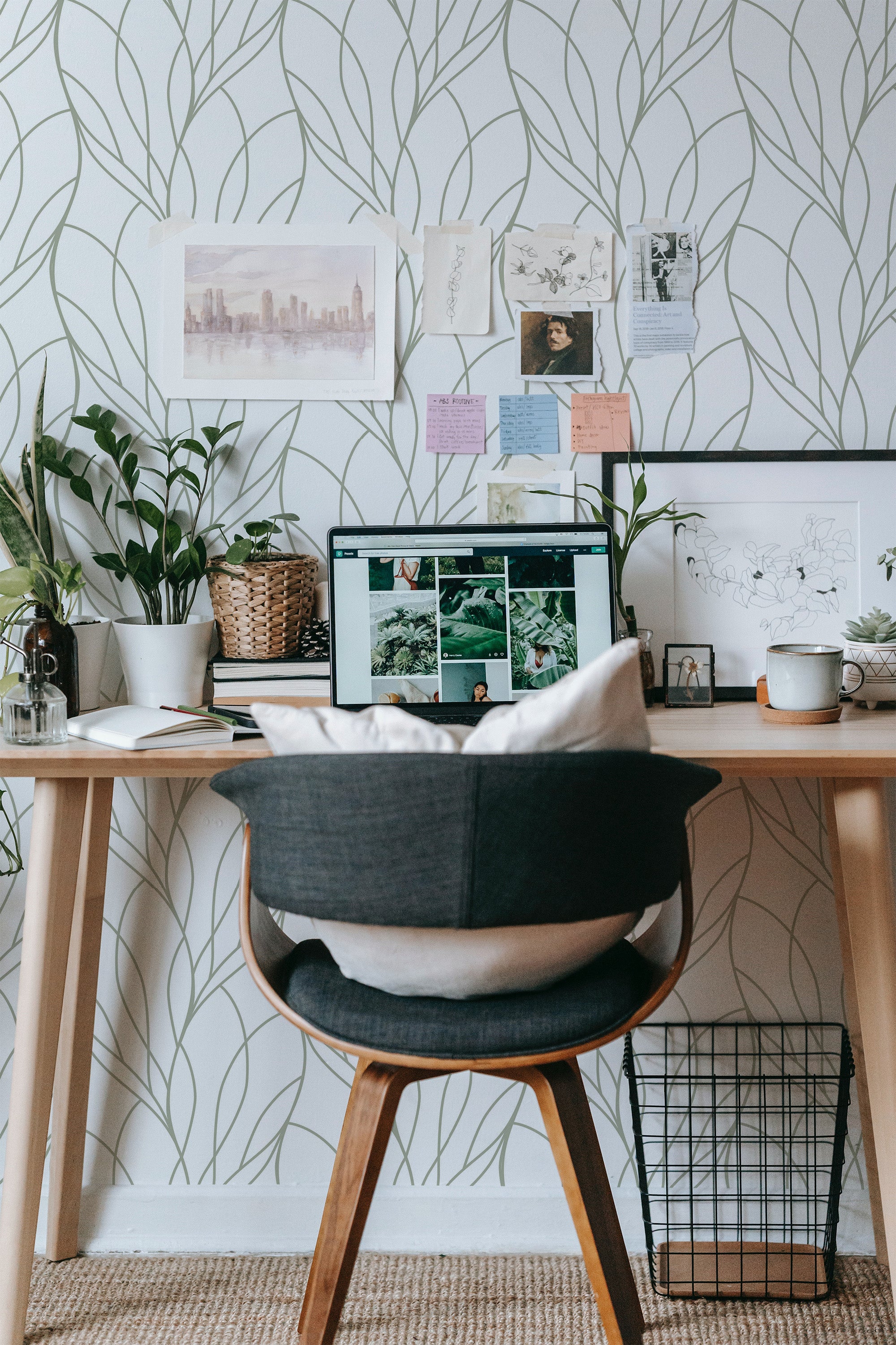 Self-adhesive wallpaper with a wavy line pattern in a room, complementing a workspace with a computer, chair, plants, and framed artwork.