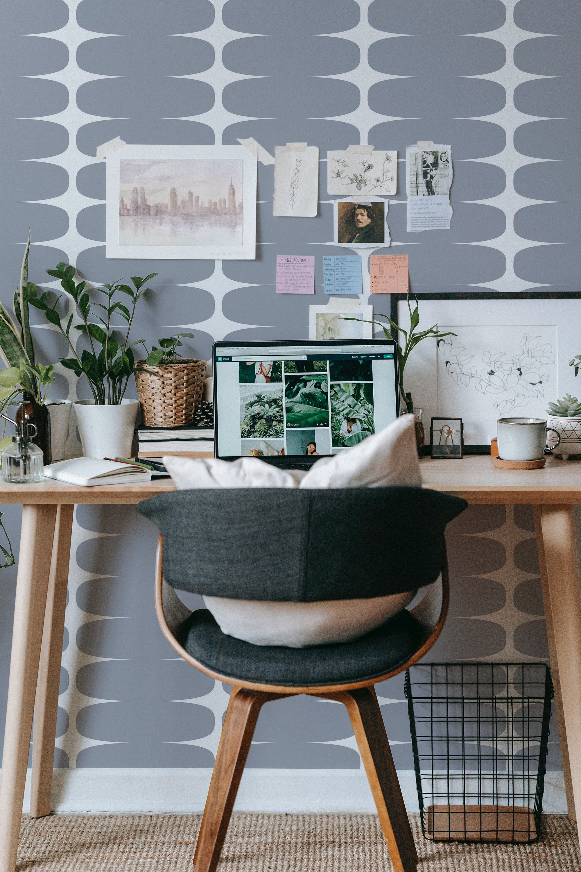 Self-adhesive wallpaper with a grey and white striped pattern in a home office setting, complementing a neatly organized desk with a chair, laptop, and decorative plants.