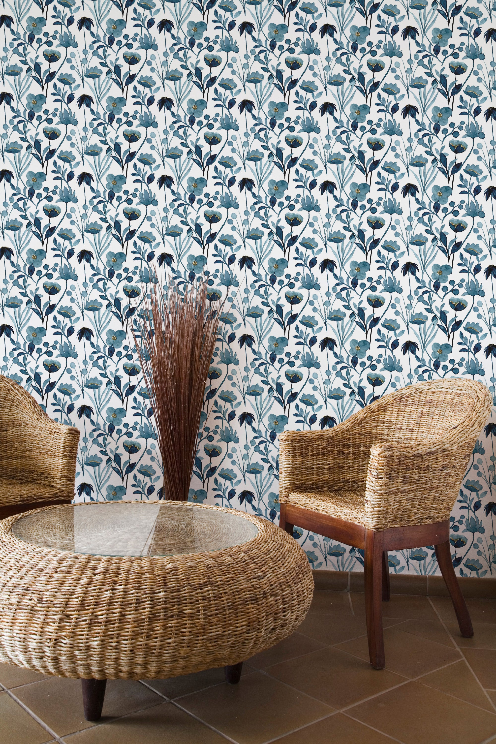 Self-adhesive Blue watercolor floral wallpaper with a pattern of blue and teal botanical motifs on a room wall, accompanied by wicker furniture.