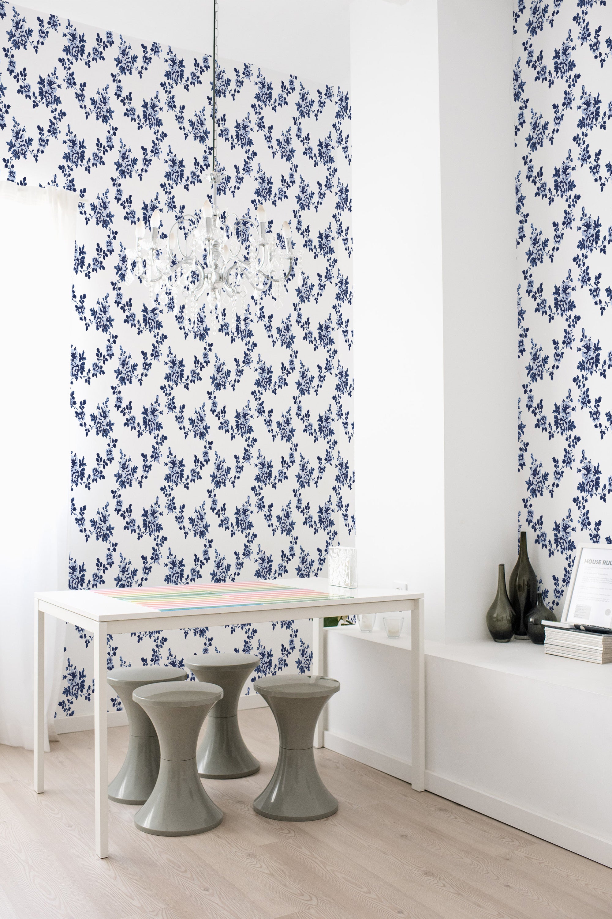 A room with white and blue floral Farmhouse design wallpaper on one wall, complemented by minimalist furniture and a chandelier, creating a cozy and traditional wallpaper ambiance.