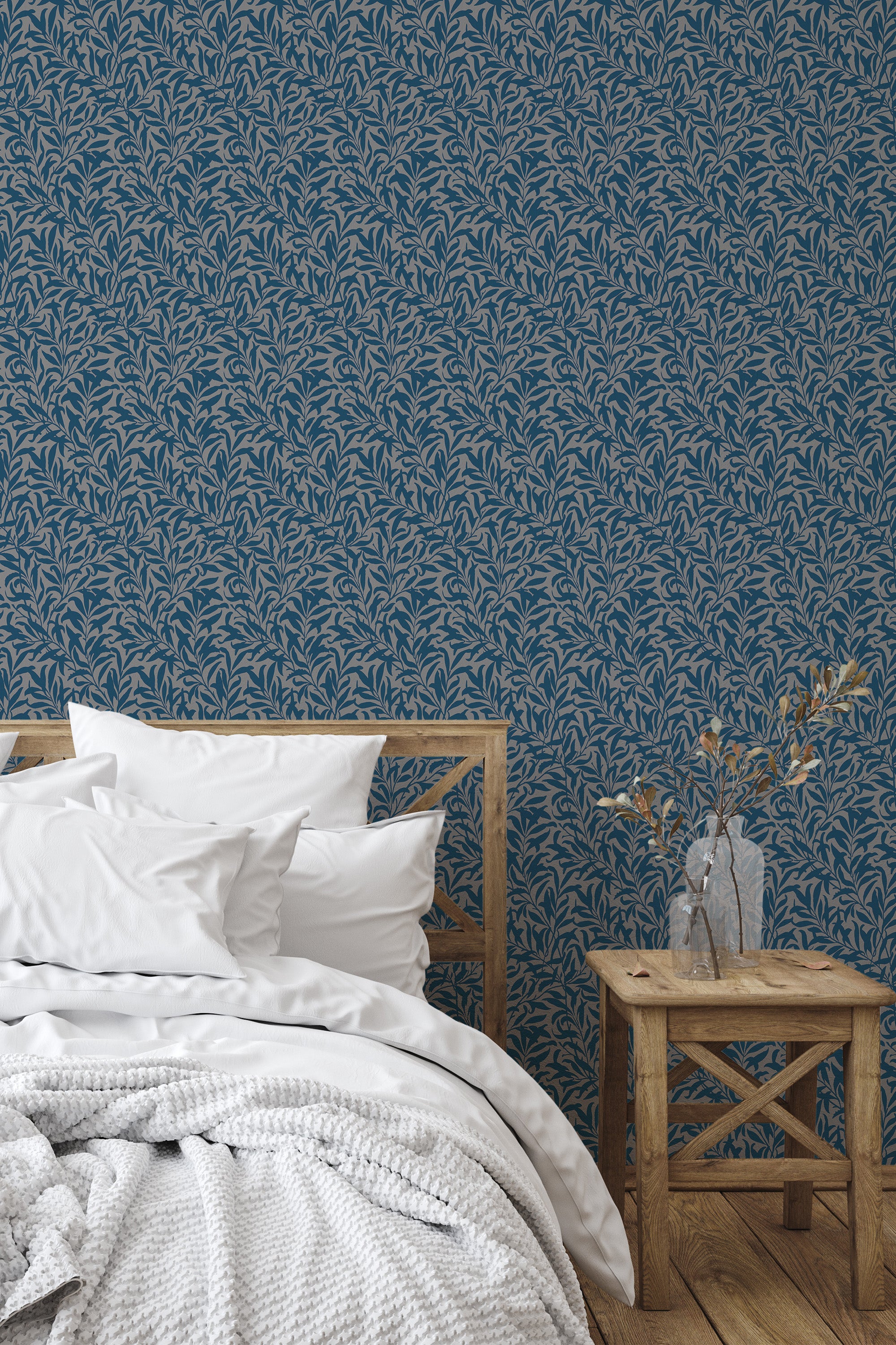 Self-adhesive dark seamless leaves wallpaper covering a bedroom wall, with intricate leaf patterns in shades of blue and white bedding.