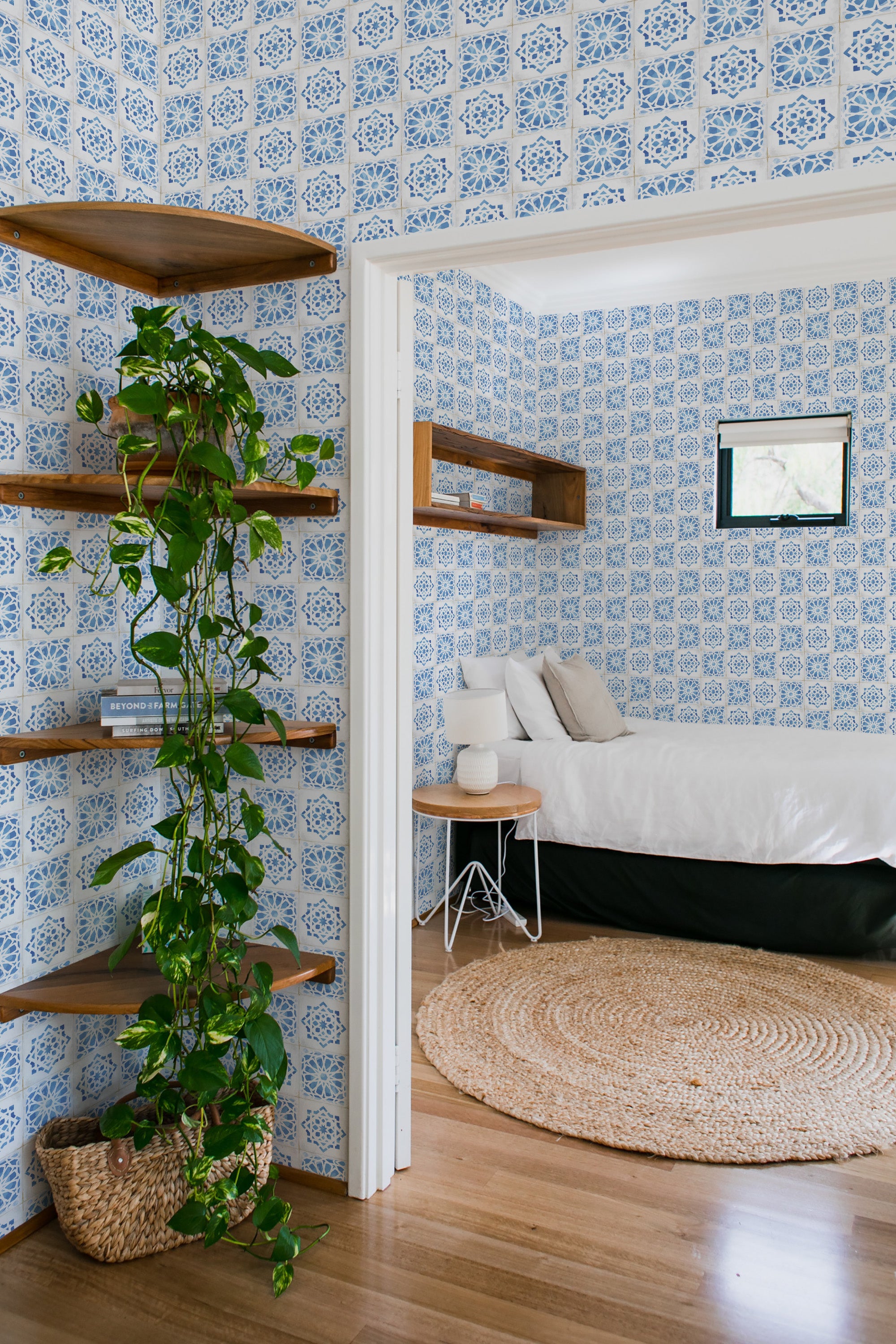 An image showing a room with blue and white mosaic tile pattern on the wallpaper. The design consists of intricate geometric patterns arranged symmetrically on all walls. Traditional wallpaper.