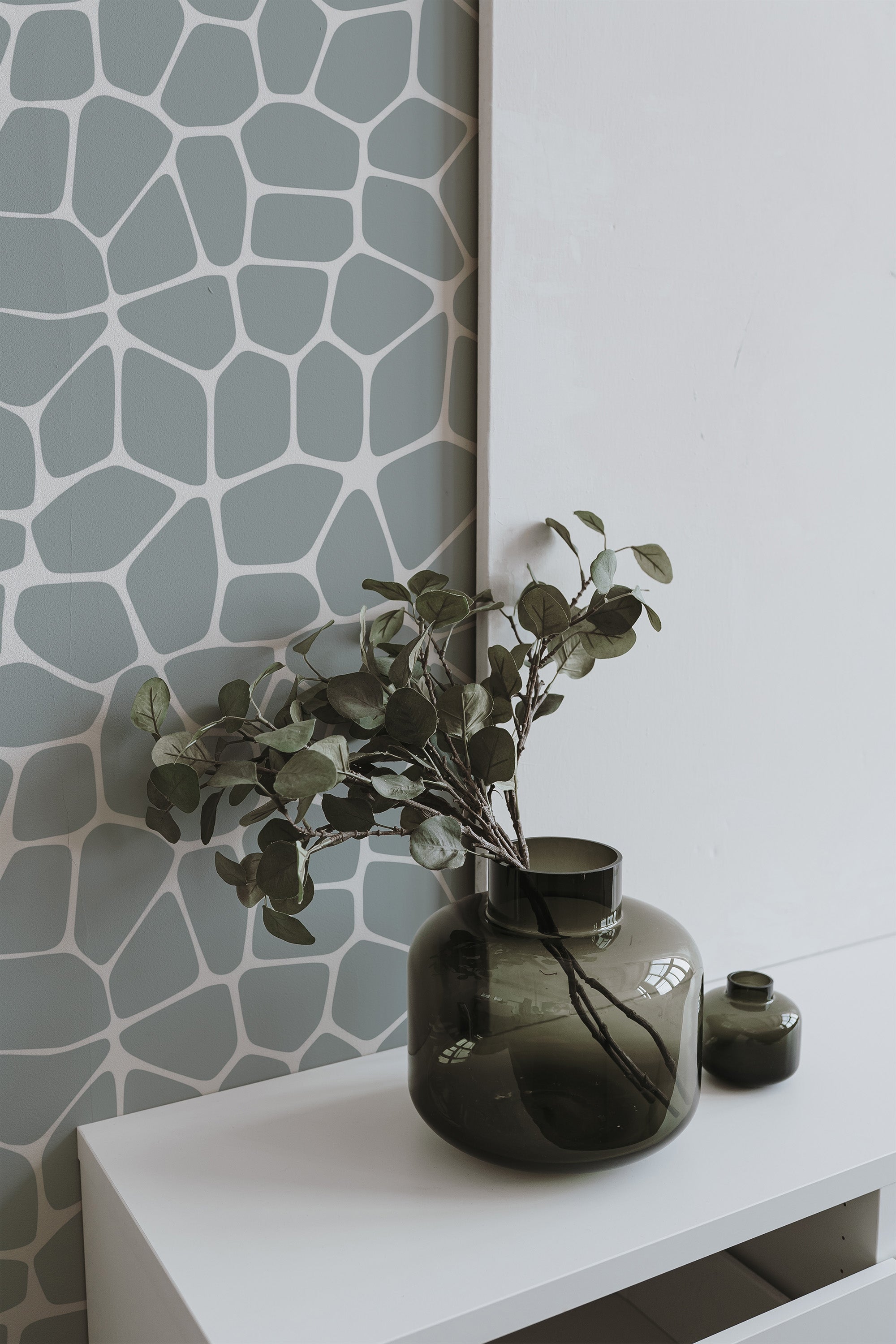Self-adhesive wallpaper with a large terrazzo pattern in muted shades of green and white, creating an abstract, irregular, stone-like appearance, complementing the modern decor with a stylish, natural touch.