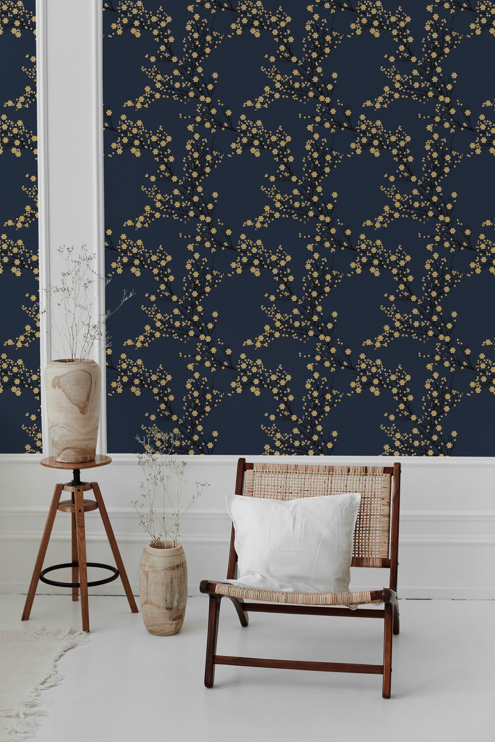 A room with dark blue wallpaper adorned with intricate golden tree branches and delicate blossoms, complemented by natural wooden furniture and minimalist decor accents. Traditional wallpaper.