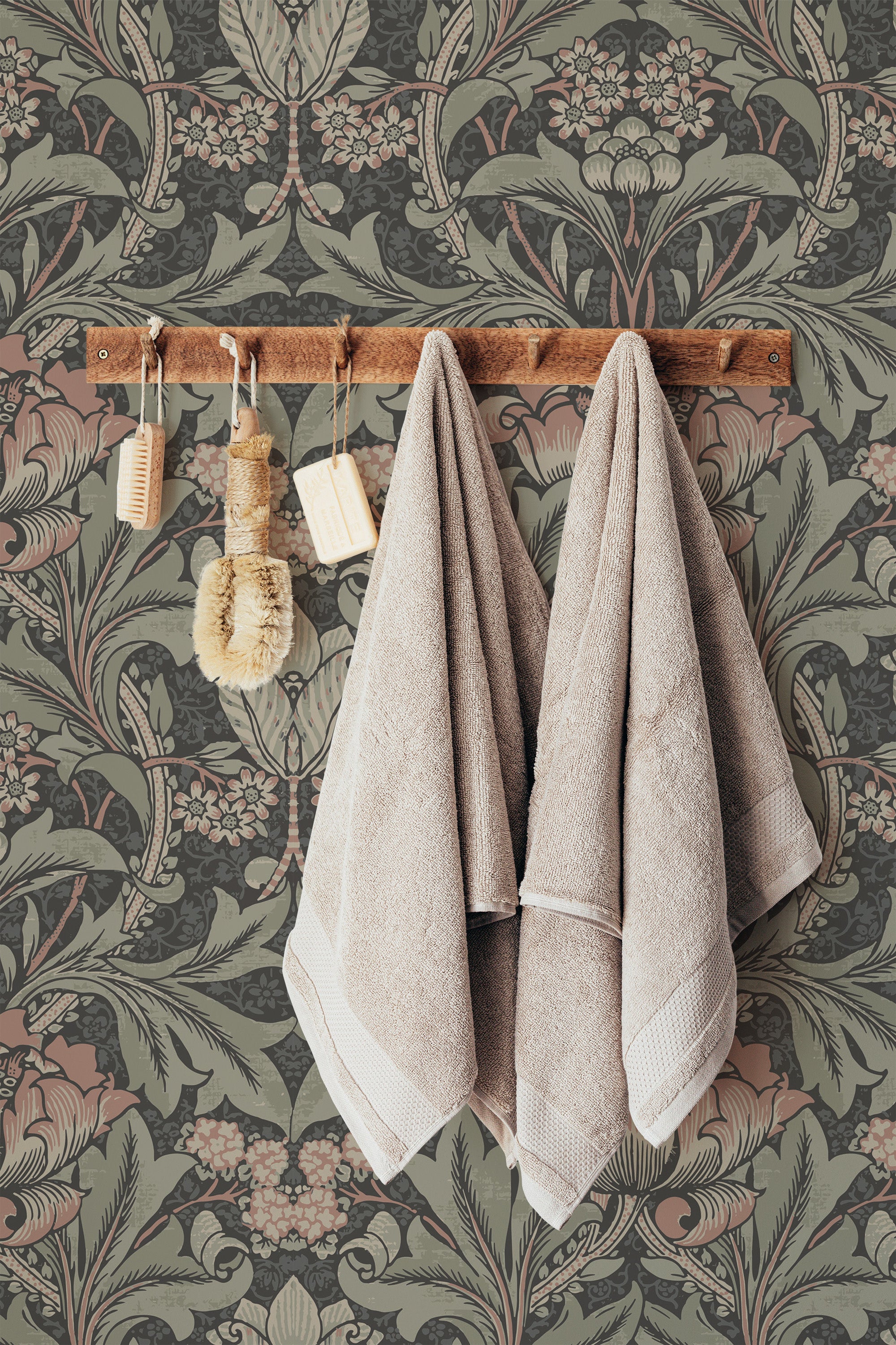 Self-adhesive wallpaper with a bold retro floral pattern in muted colors, towels hanging on a wooden rack against the decorative background.