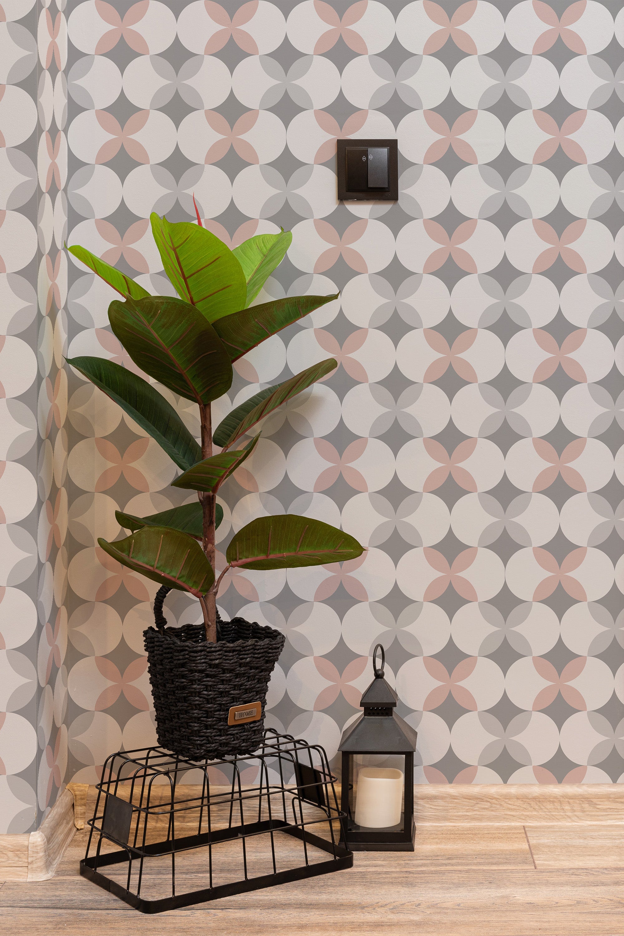 Self-adhesive wallpaper with a dotted retro print pattern in muted shades, accompanied by a potted plant and lantern on the floor.