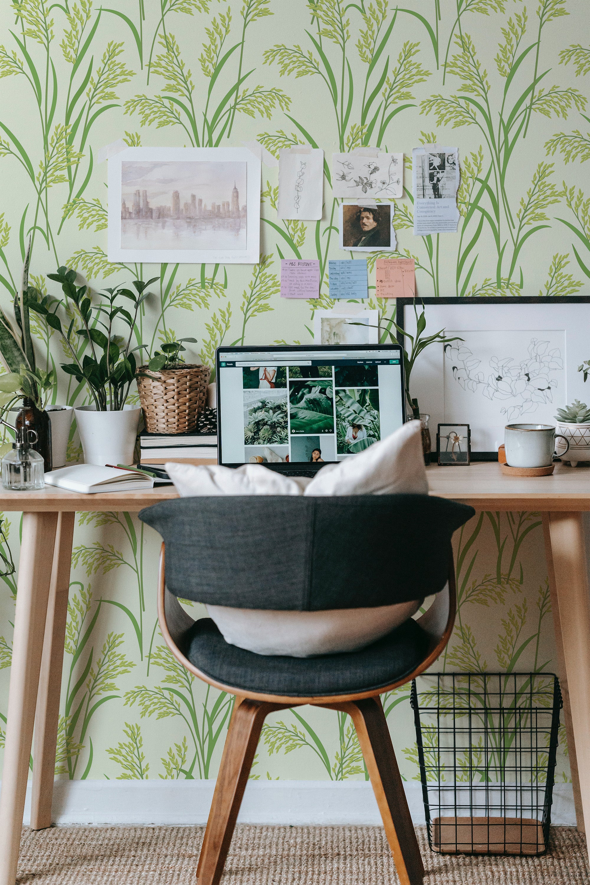 Self-adhesive wallpaper with rice plant pattern in shades of green on a home office wall, accented with a desk and decor.