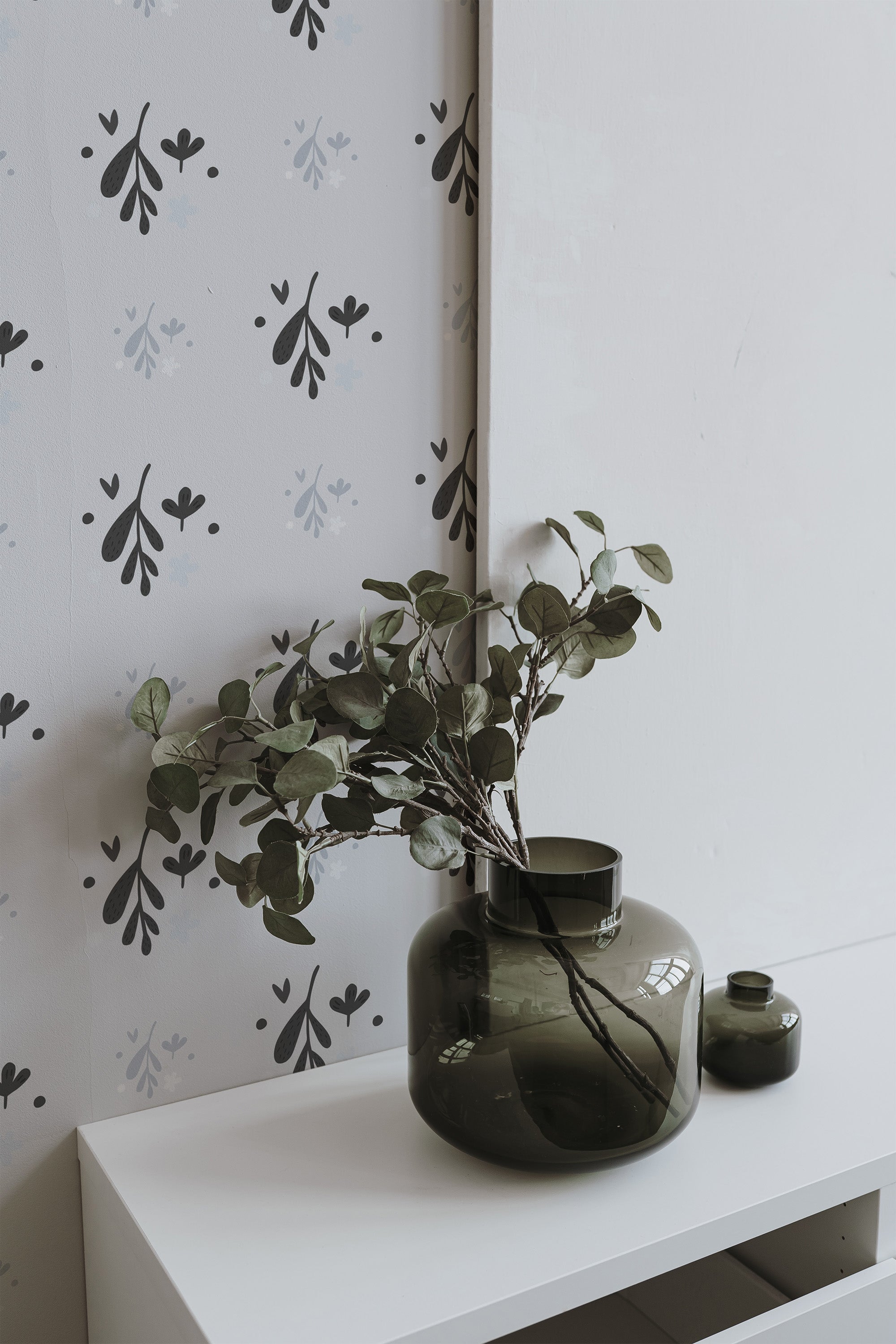 Self-adhesive wallpaper with a minimal leaves design in muted tones, showcasing simple, delicate leaf patterns on a light background, adding a subtle natural element to the room decor.