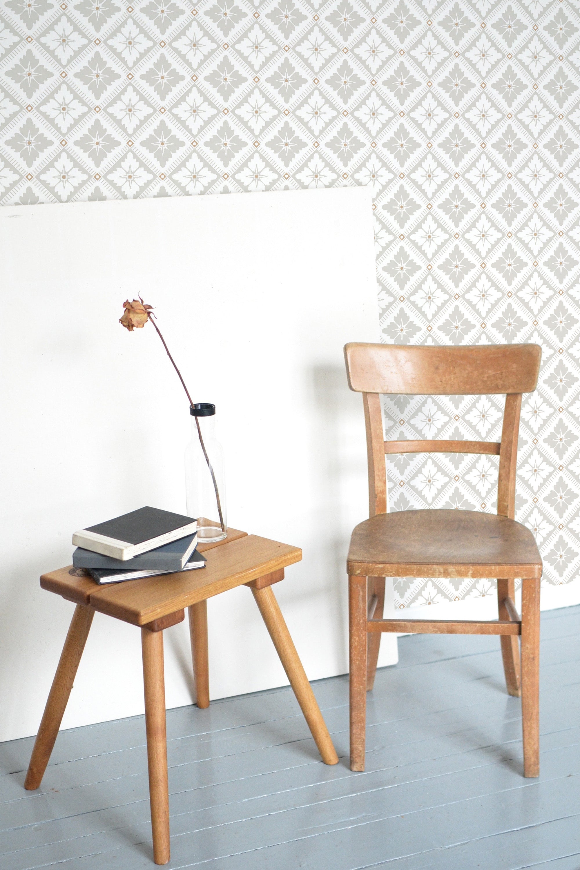 Self-adhesive wallpaper with a neutral vintage tile design in a soft beige and white color scheme. The intricate pattern showcases a geometric layout with small floral motifs, creating a classic, understated look.