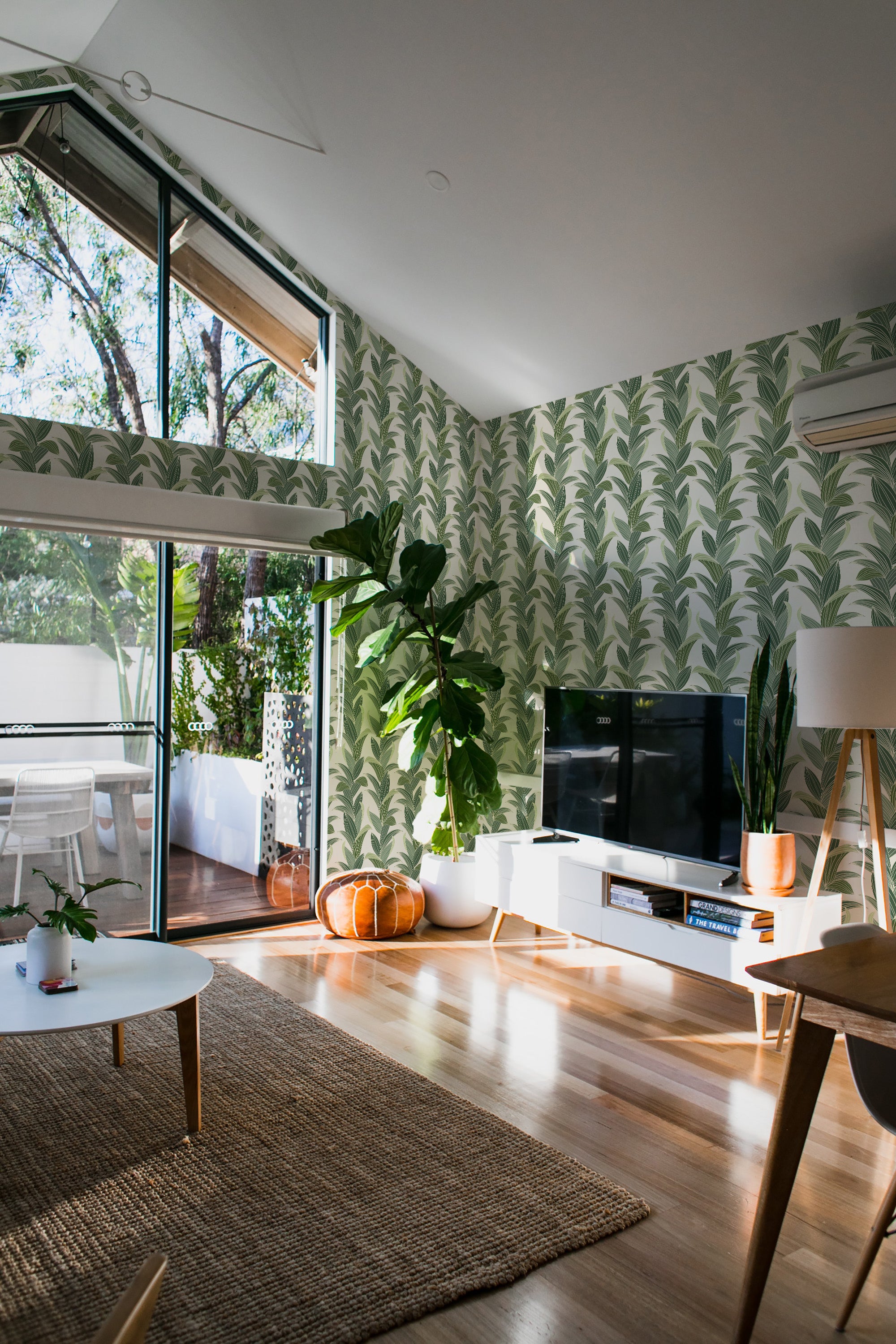 A room with a Tropical leaf wallpaper design that covers the walls in a leafy green pattern. It is traditional wallpaper.