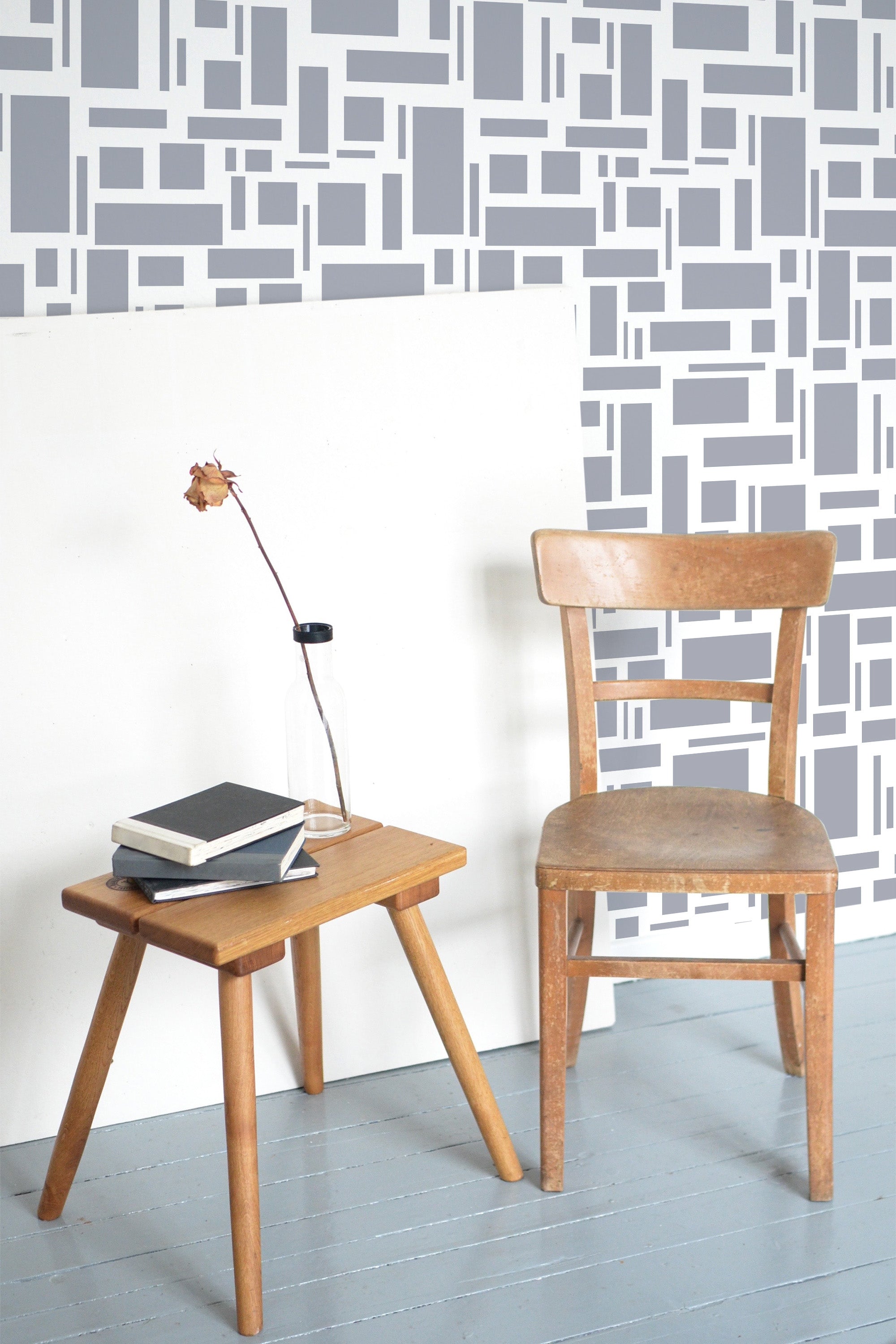 Self-adhesive wallpaper with a small tile design consisting of gray and white geometric shapes, including rectangles and squares, creating a modern and minimalist pattern on the wall.