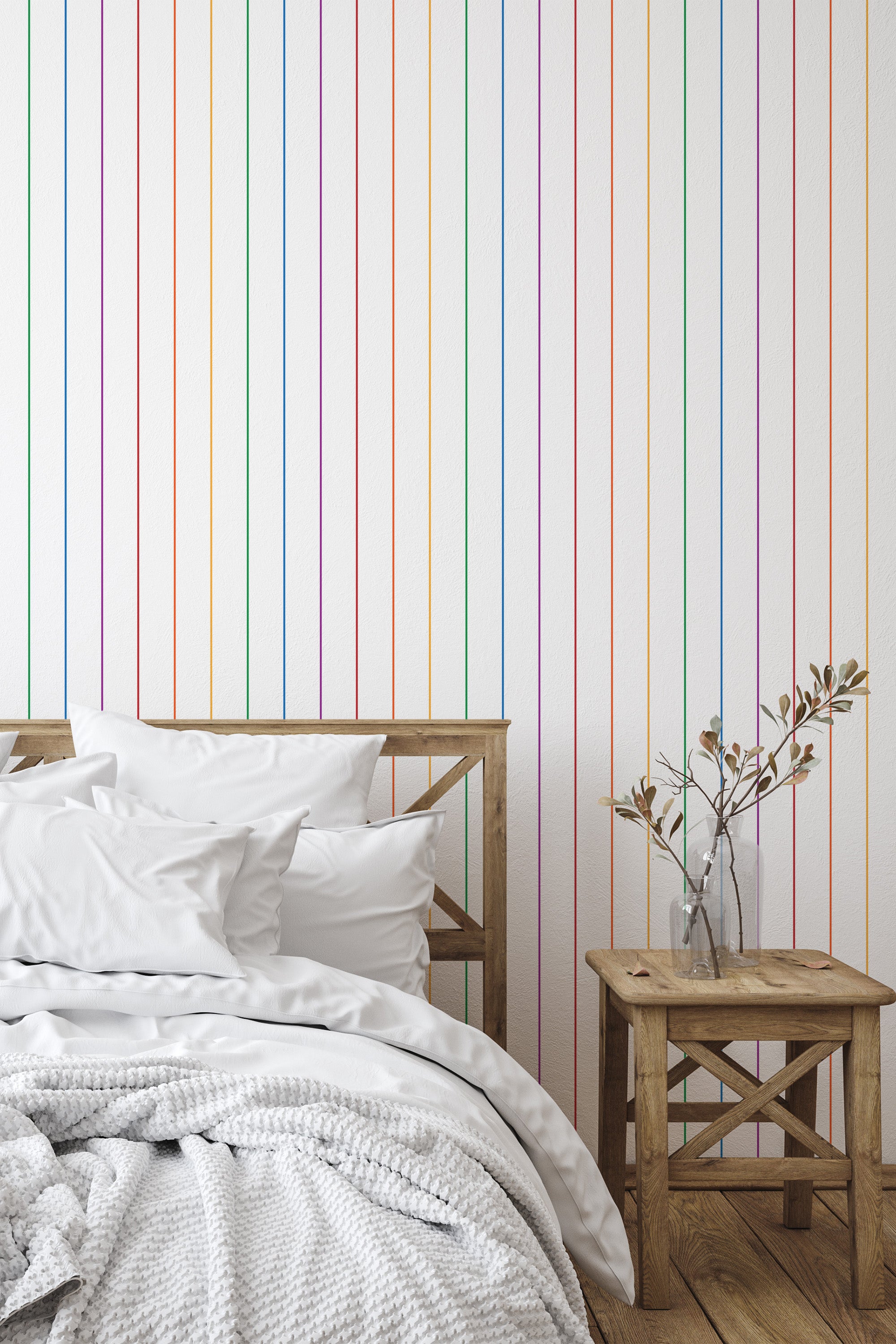 Self-adhesive wallpaper with vertical rainbow-colored stripes on a white background, installed in a bedroom with neutral-toned decor.