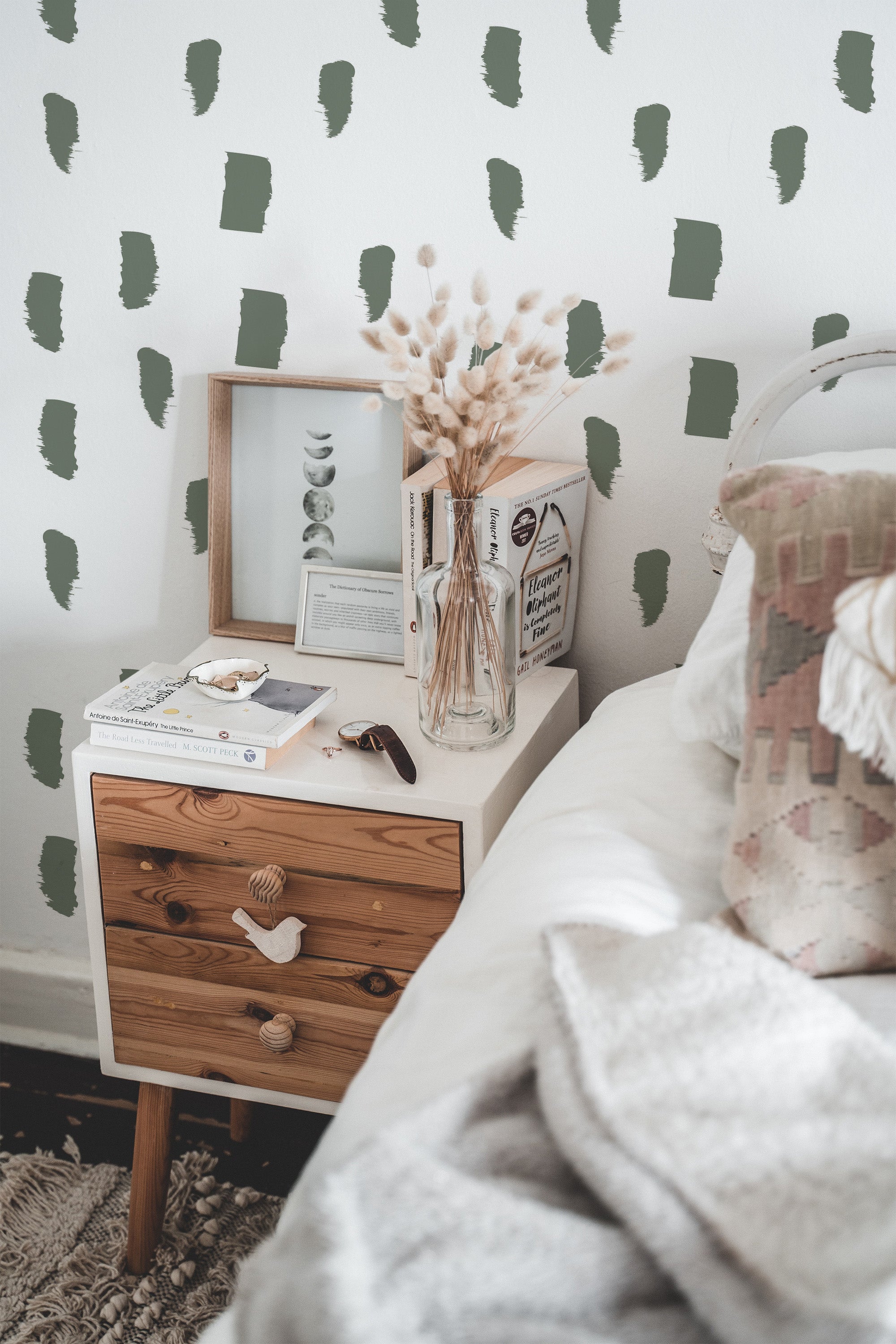 Self-adhesive wallpaper with a paintbrush stroke pattern in muted green tones spread evenly across a white background, providing a minimalist and artistic touch to the room.