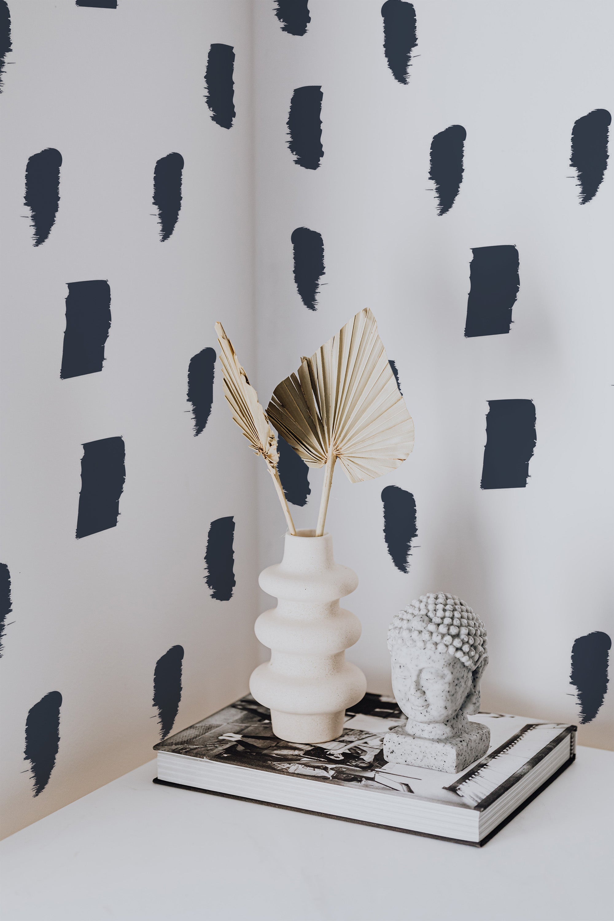 Self-adhesive wallpaper design with navy blue brushstroke patterns scattered on a white background, giving the wall an artistic and modern appearance.