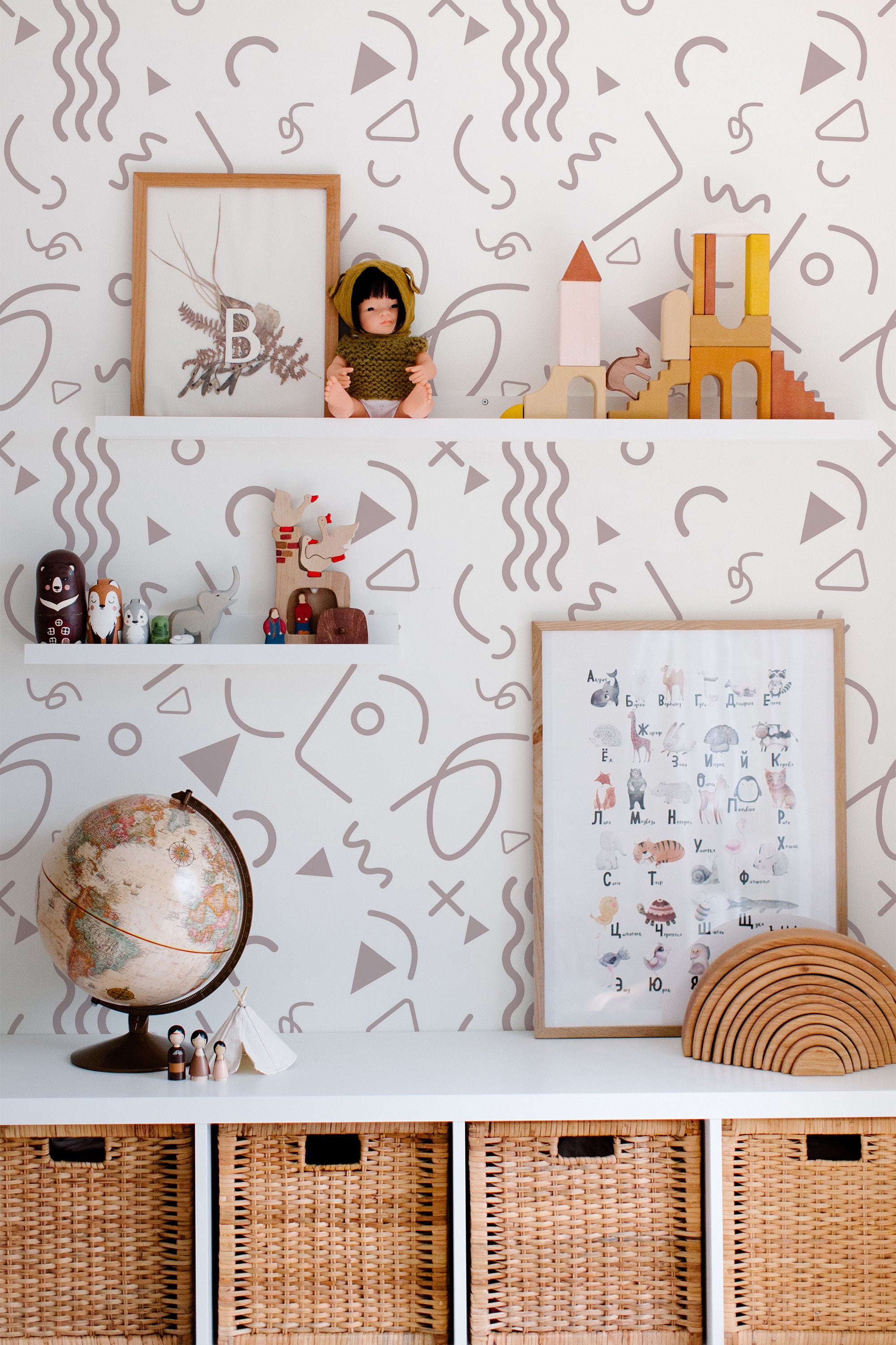 Self-adhesive wallpaper with a playful design of abstract squiggles, triangles, circles, and other geometric shapes in soft pastel tones on a white background.