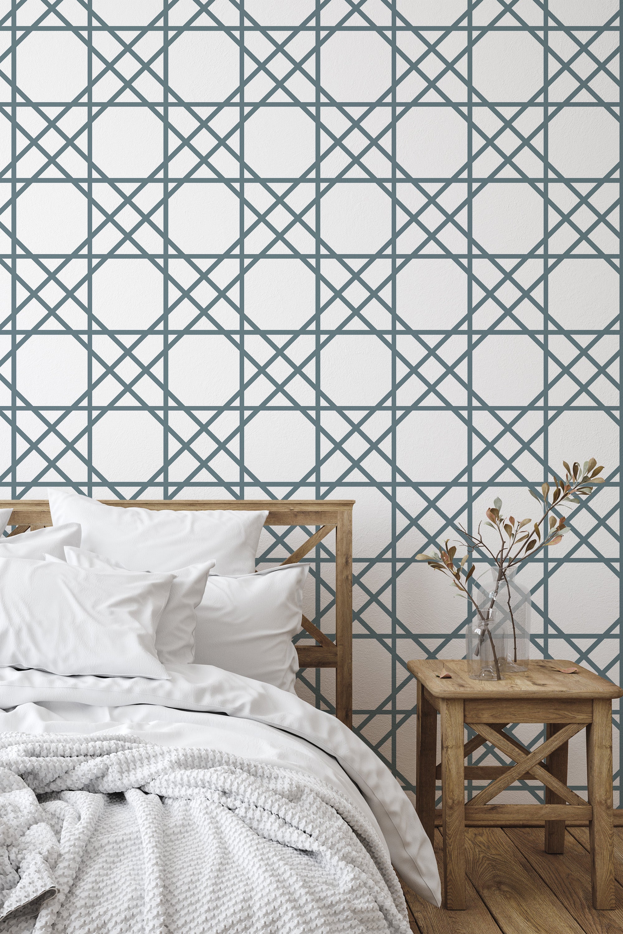 Self-adhesive wallpaper with an Oriental tile design, featuring an intricate grid of blue geometric patterns against a white background, complementing the wooden bed frame and side table in a cozy bedroom setting.