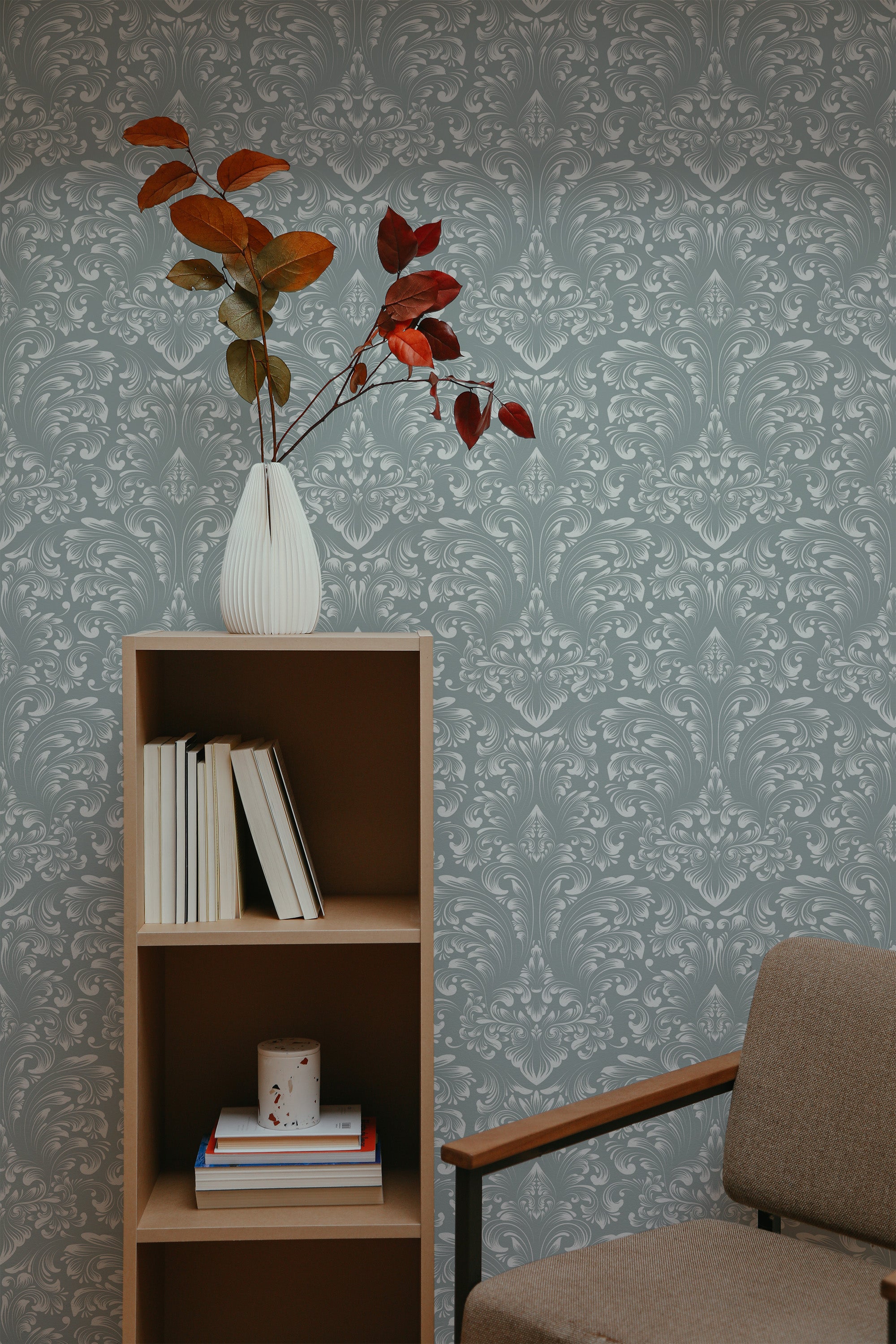 Self-adhesive Classic Damask wallpaper with intricate floral patterns in a room with a bookshelf and brown chair.